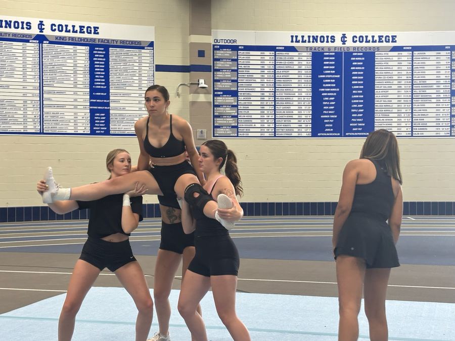 Cheer athletes building a stunt on the practice floor