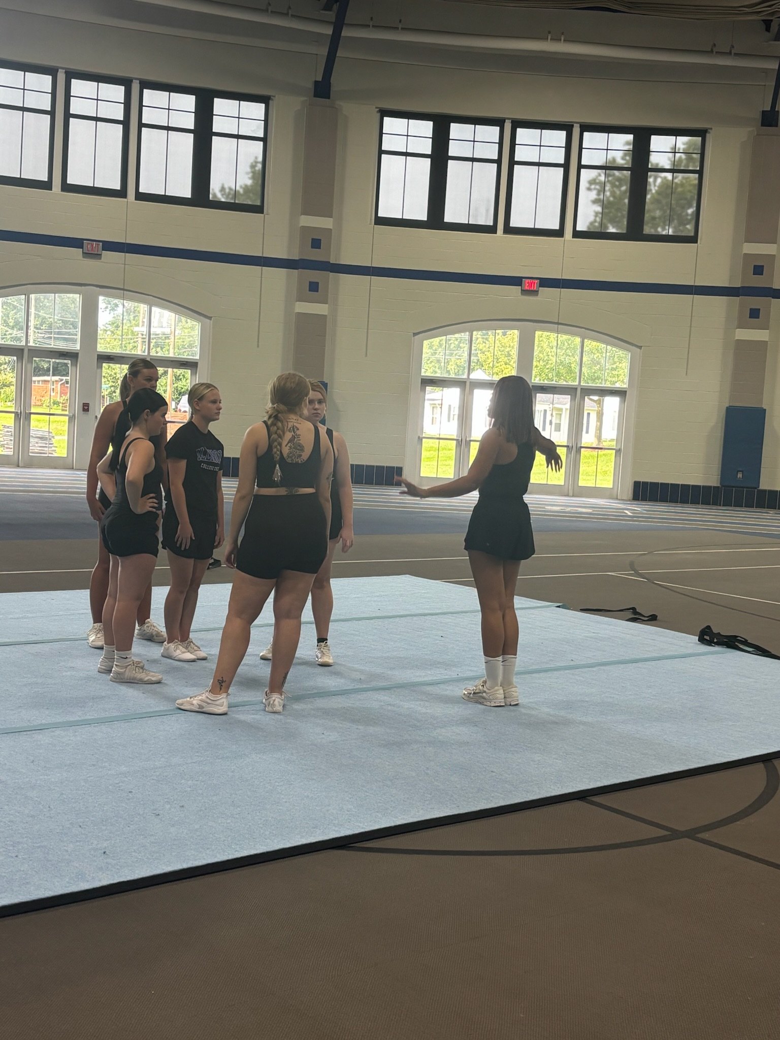Cheer athletes warming up on the practice floor at a CheerDays clinic in the Illinois College fieldhouse